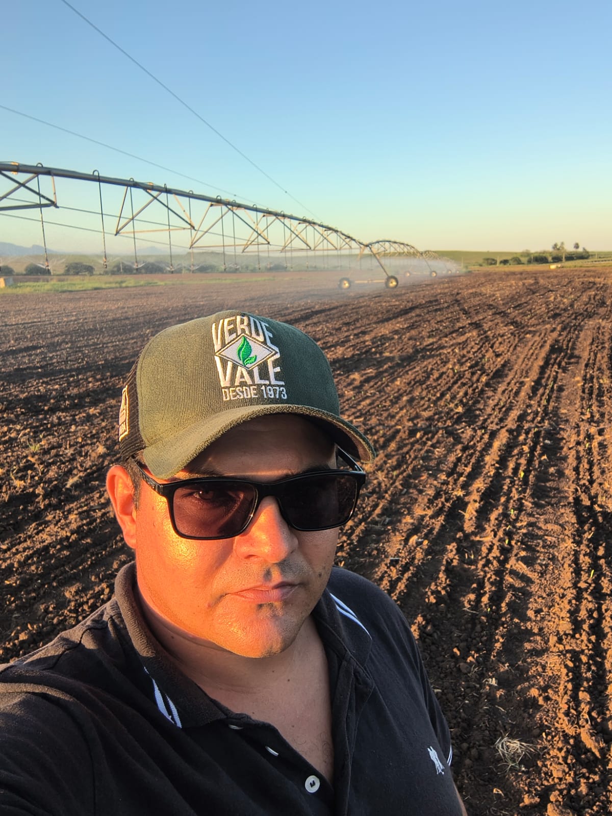 Maycon Alves no campo com pivô de irrigação ao fundo